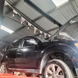 A vehicle on the lift inside the AAA Rego and Repair workshop